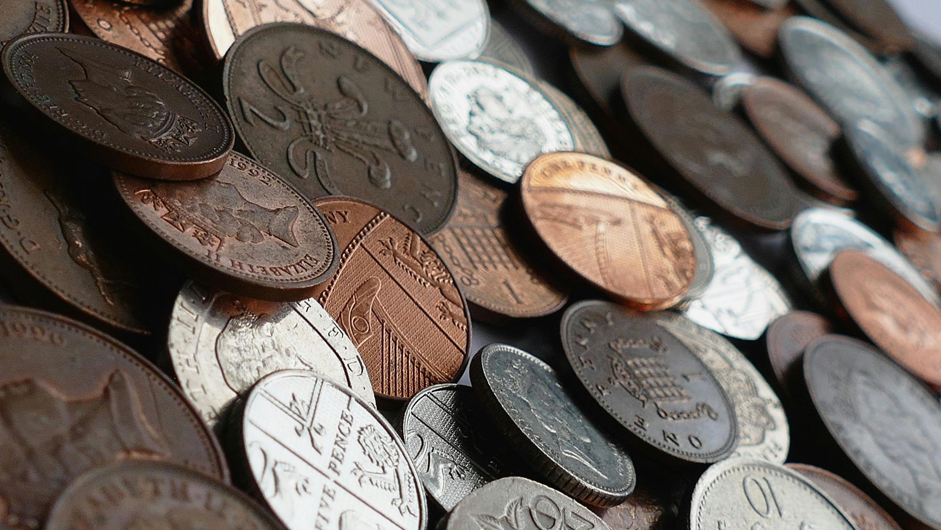 A pile of coins including a penny and a dime