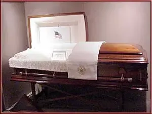 A coffin is sitting on a table in a room with the lid open.
