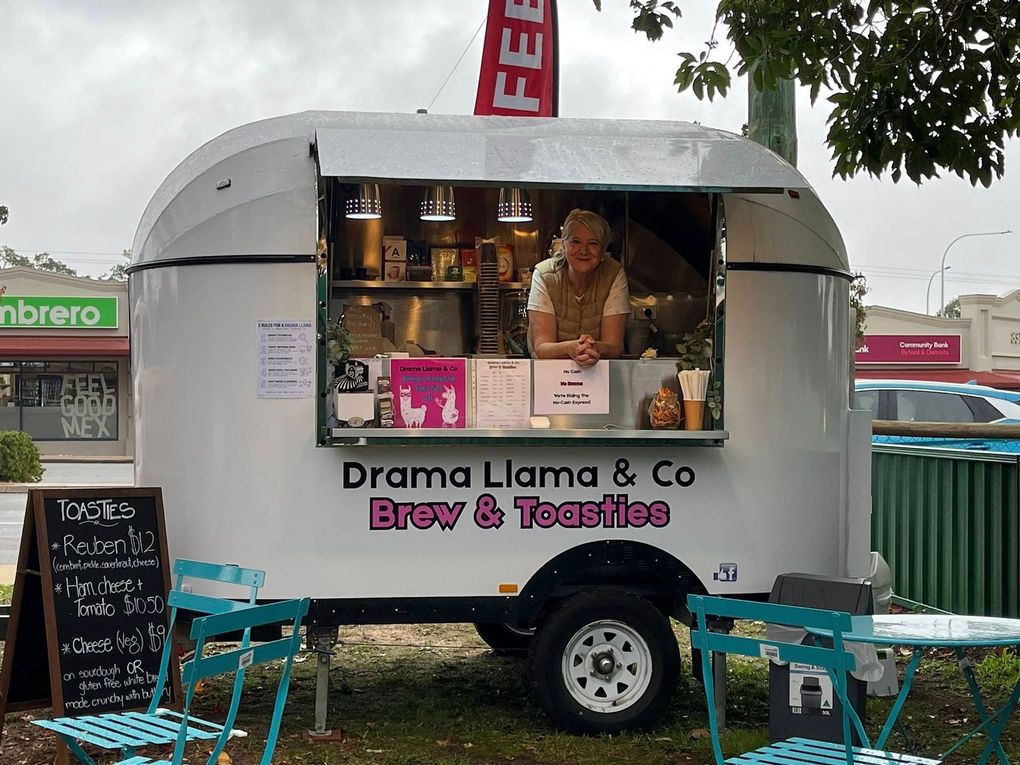 Food truck labeled “Drama Llama & Co Brew & Bites” with a vendor serving drinks from the window