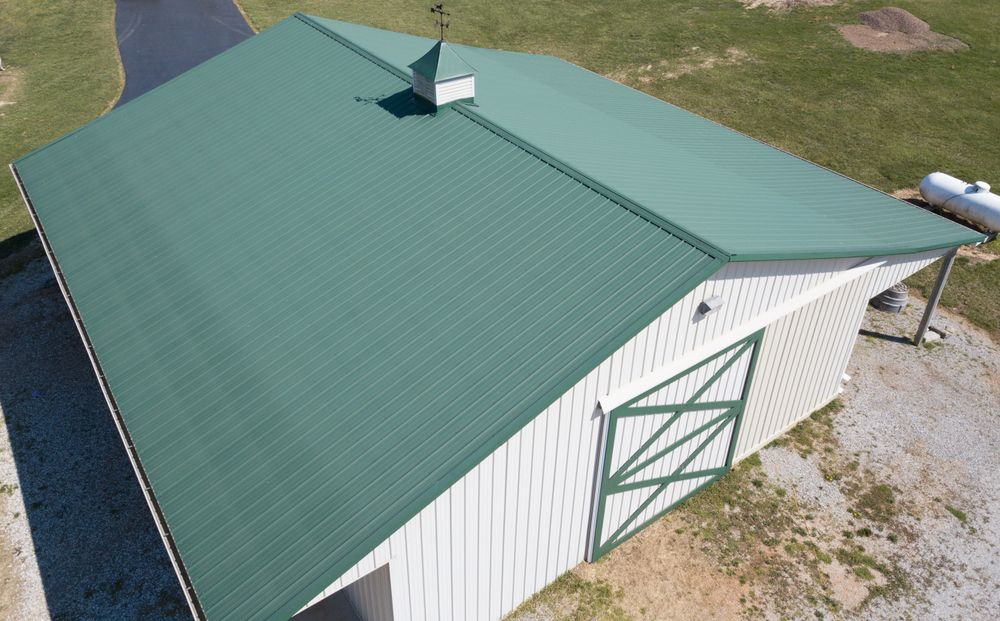 Green Metal Roof on a White Barn With a Gas Tank to the Side — Callaway Roofing & Construction in Dubbo, NSW