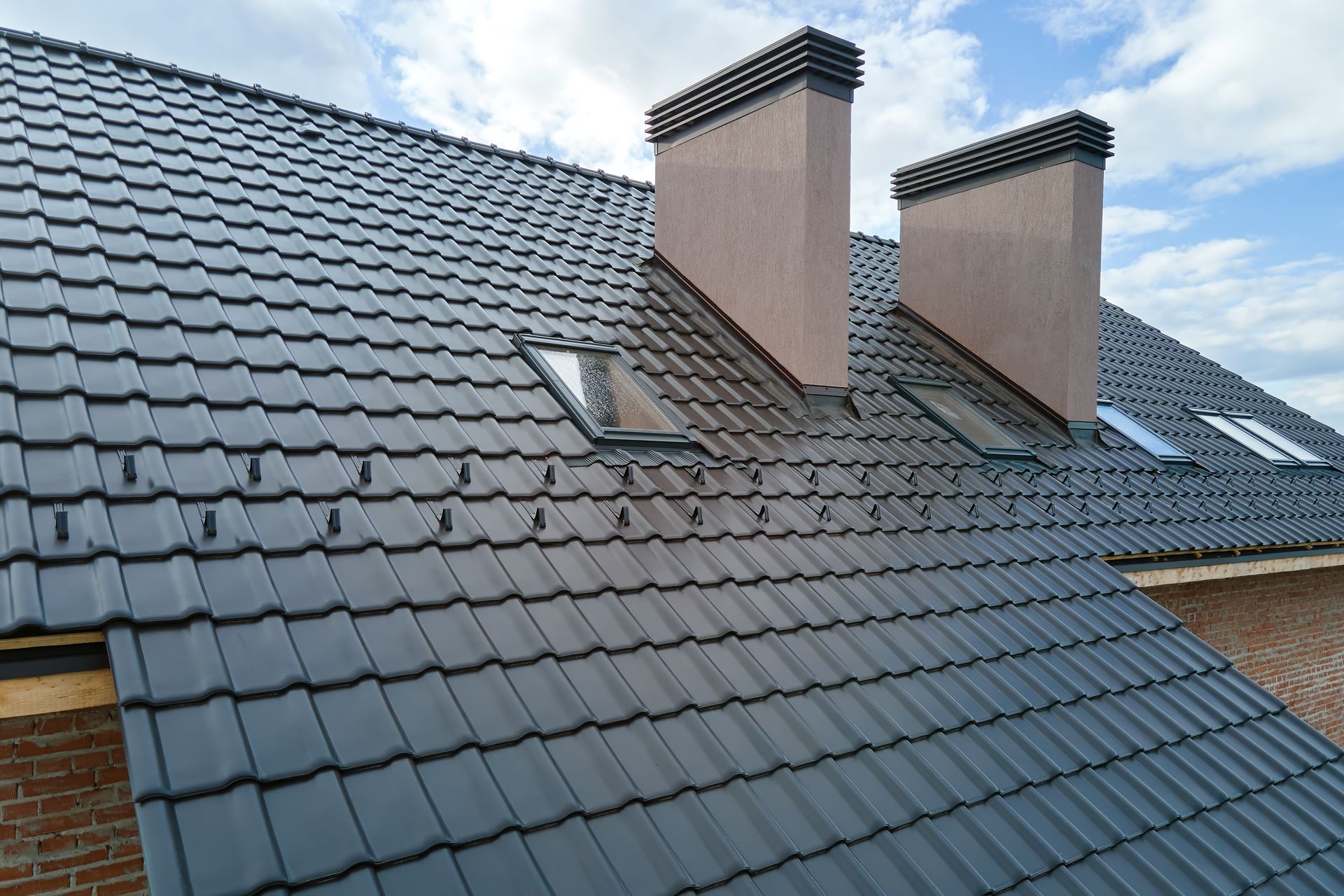 Gray Tiled Roof With Two Chimneys and Skylights — Callaway Roofing & Construction in Narrabri, NSW