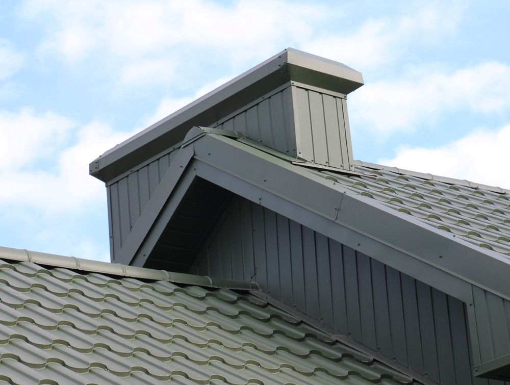 Green Chimney and Roof Against a Cloudy Sky — Callaway Roofing & Construction in Warren, NSW