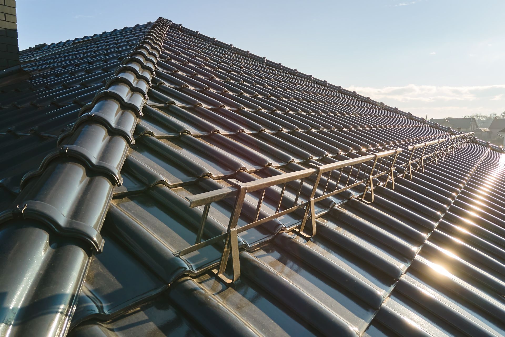 Dark Tile Roof With a Safety Railing on a Sunny Day — Callaway Roofing & Construction in Cobar, NSW
