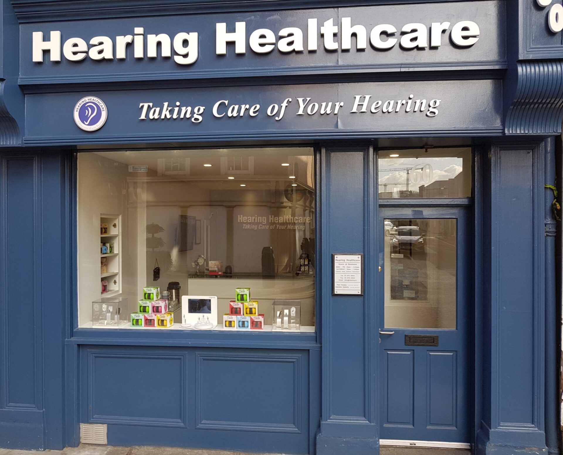 Hearing Healthcare storefront with blue paint and window display.