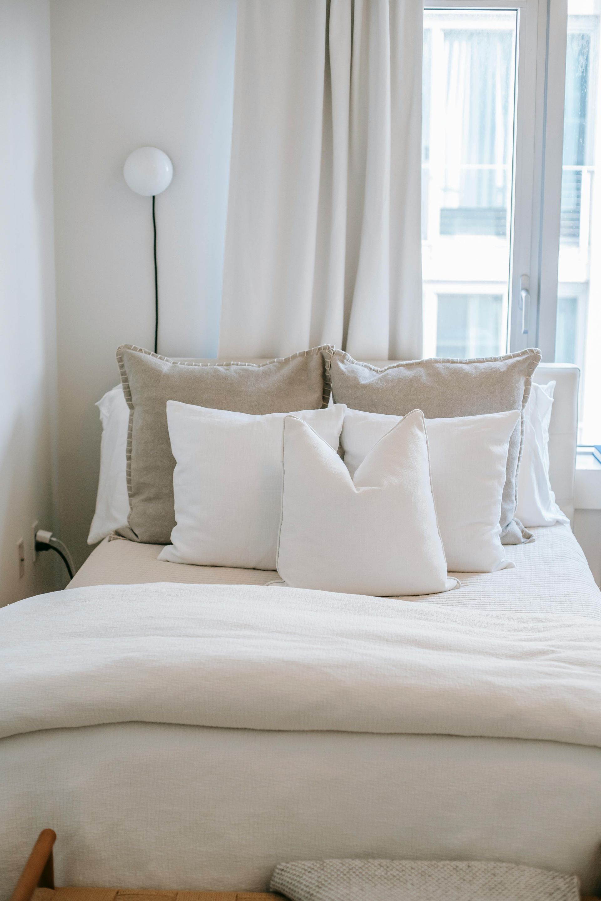 new mattress with white comforter and throw pillows