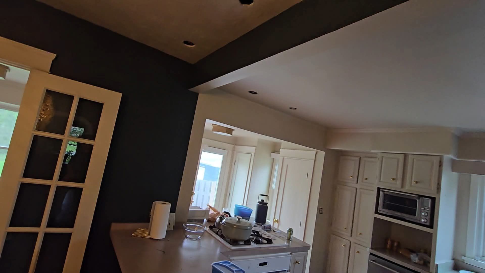 White kitchen under construction with cabinets and tools.