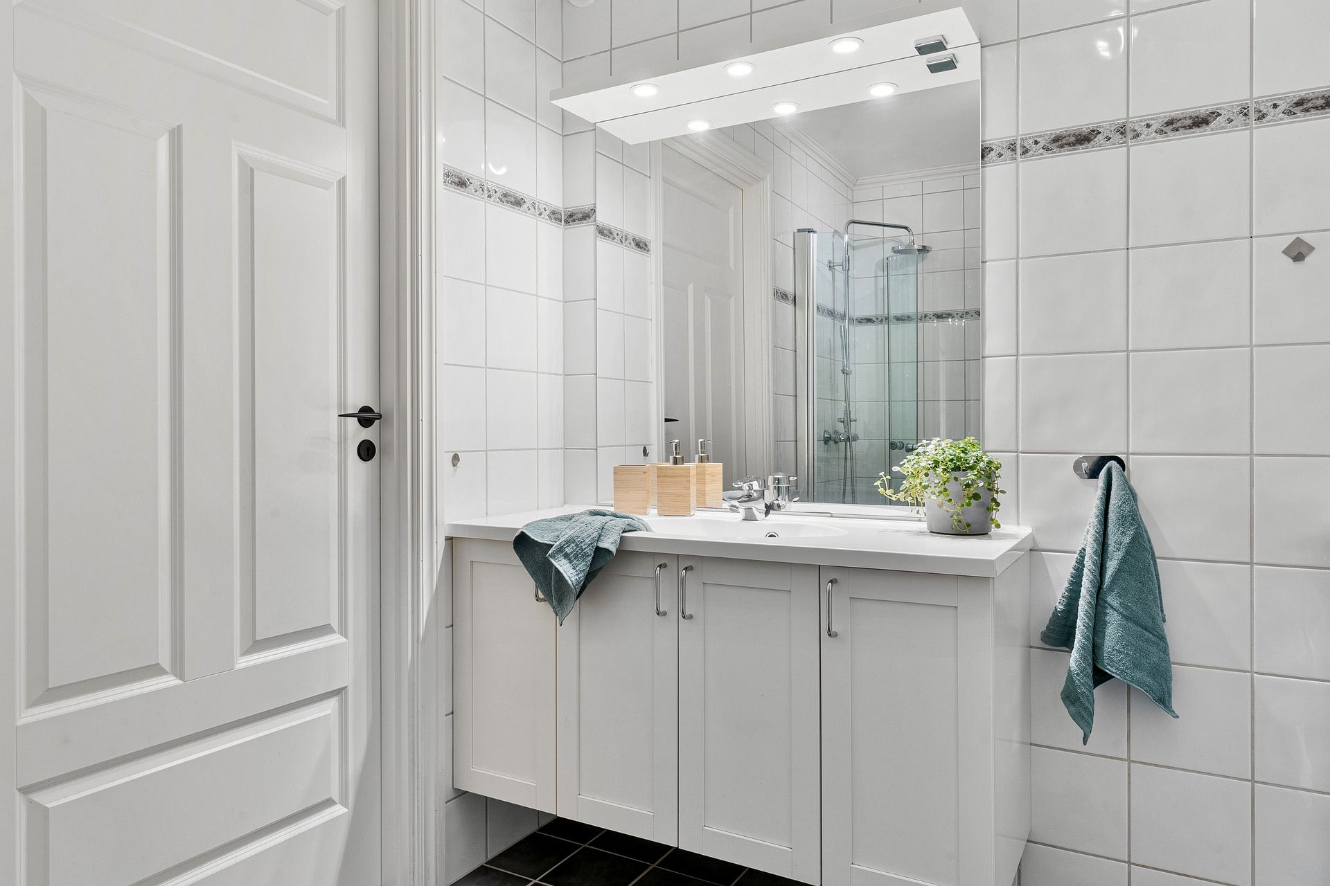 A bathroom with a sink , mirror and shower.