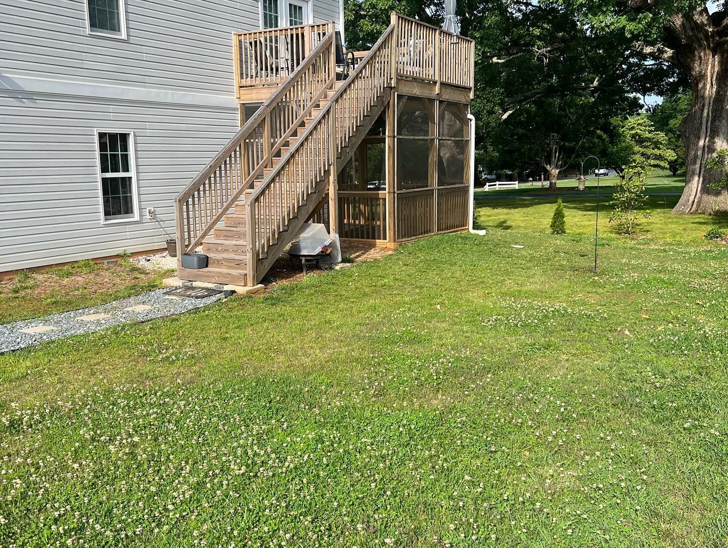 A house with a screened in porch and stairs leading up to it.