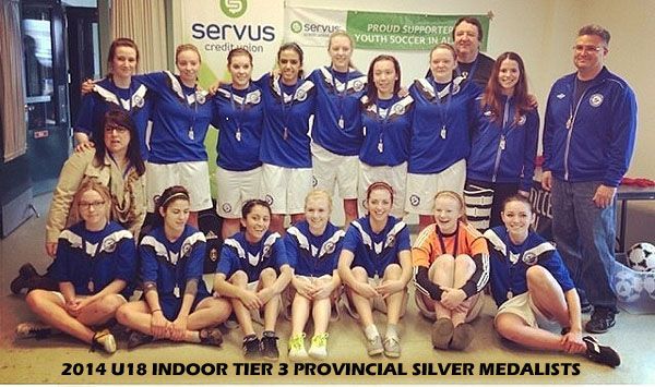 A soccer team in blue uniforms poses for a photo after winning silver medals at the 2014 indoor provincial tournament.