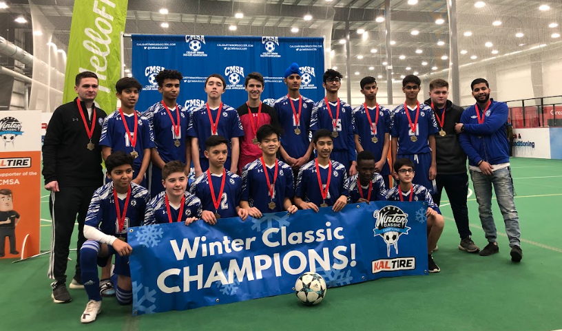 A soccer team wearing blue uniforms poses with a 