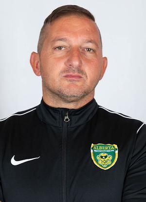 A man in a black nike jacket is posing for a picture.
