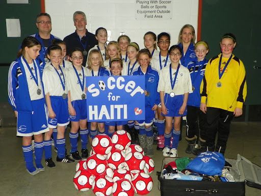 A youth soccer team holding a 