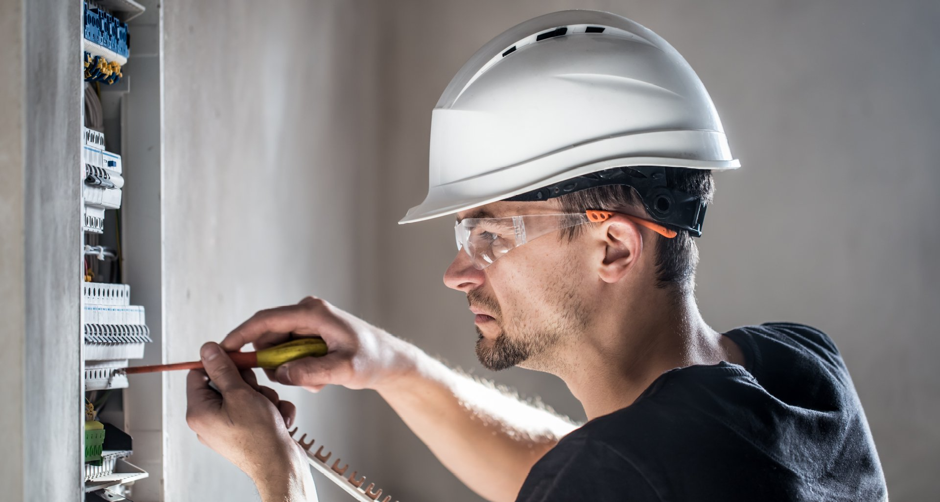 electrical technician working in a switchboard with fuses