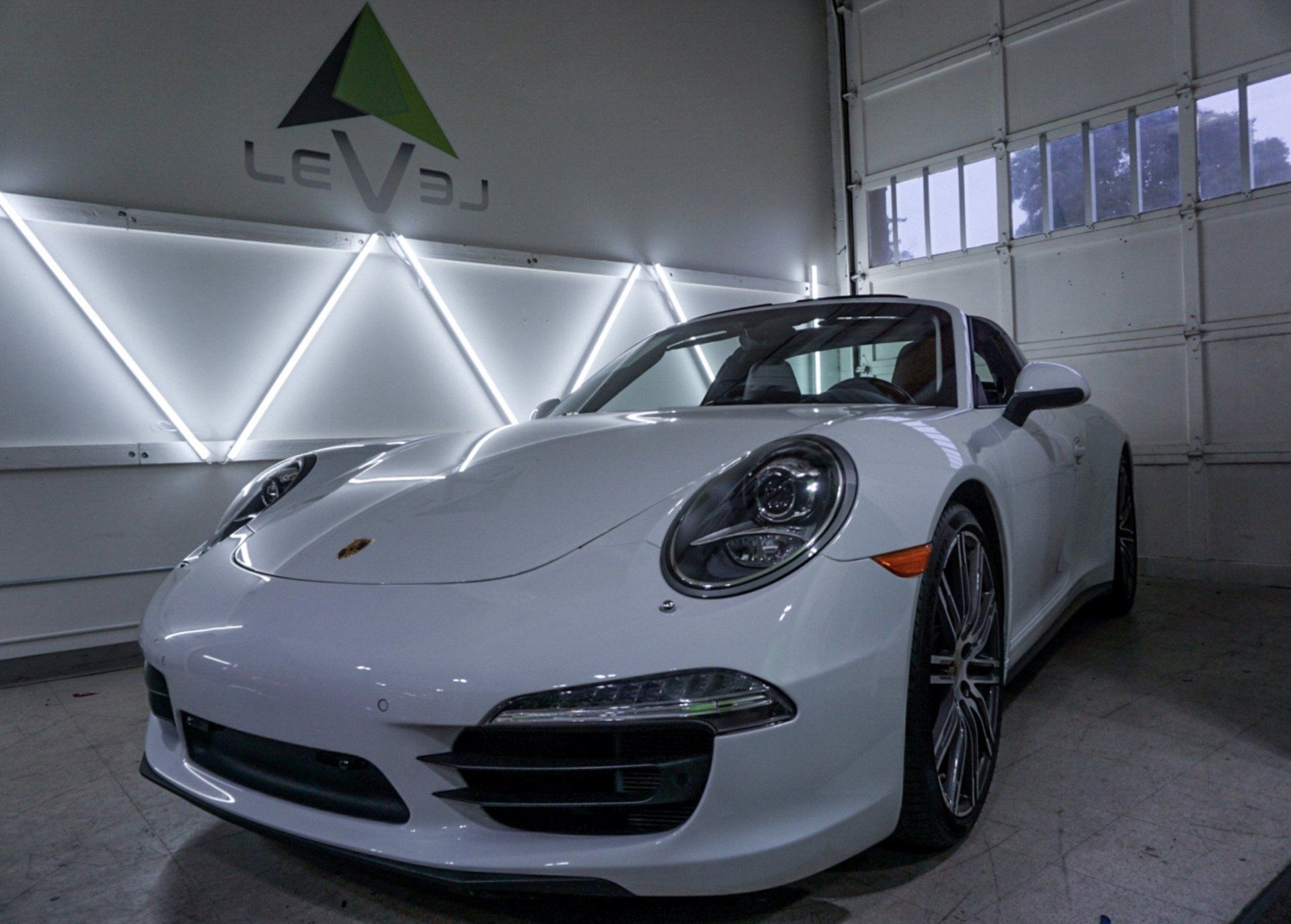 White Porsche 911 in a garage with geometric LED wall lighting