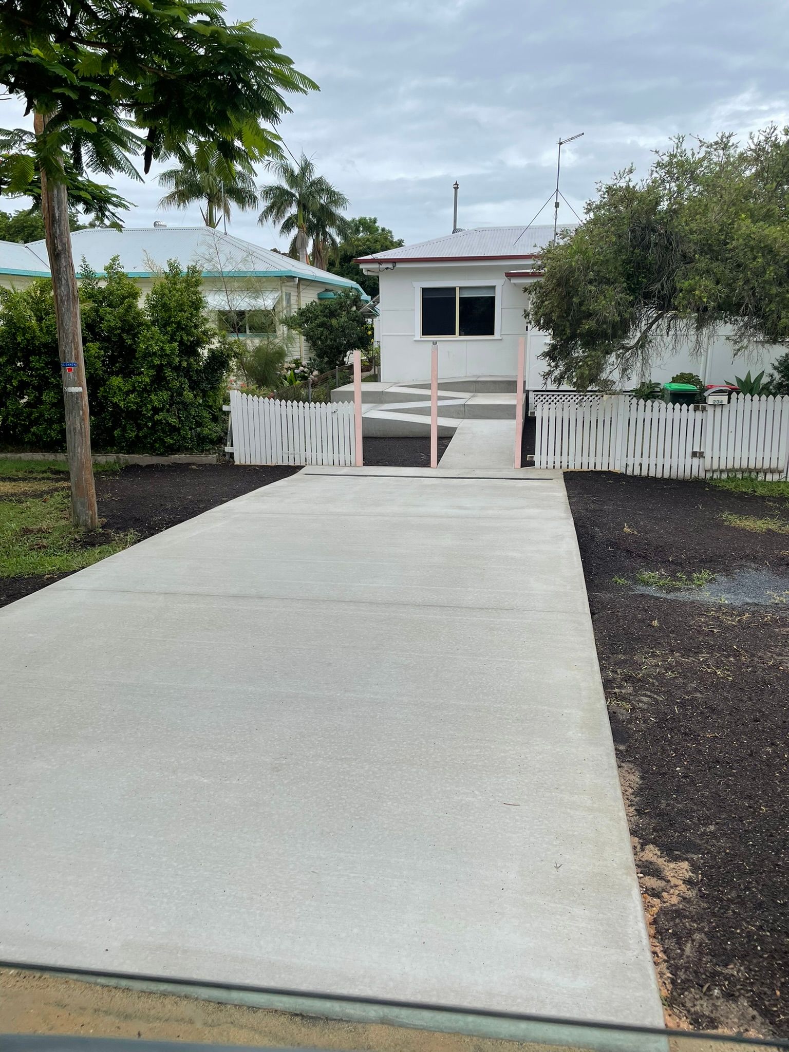 A Concrete Walkway is Being Built Next to a Drain — Grafton Concreting & Bobcat Services In South Grafton, NSW