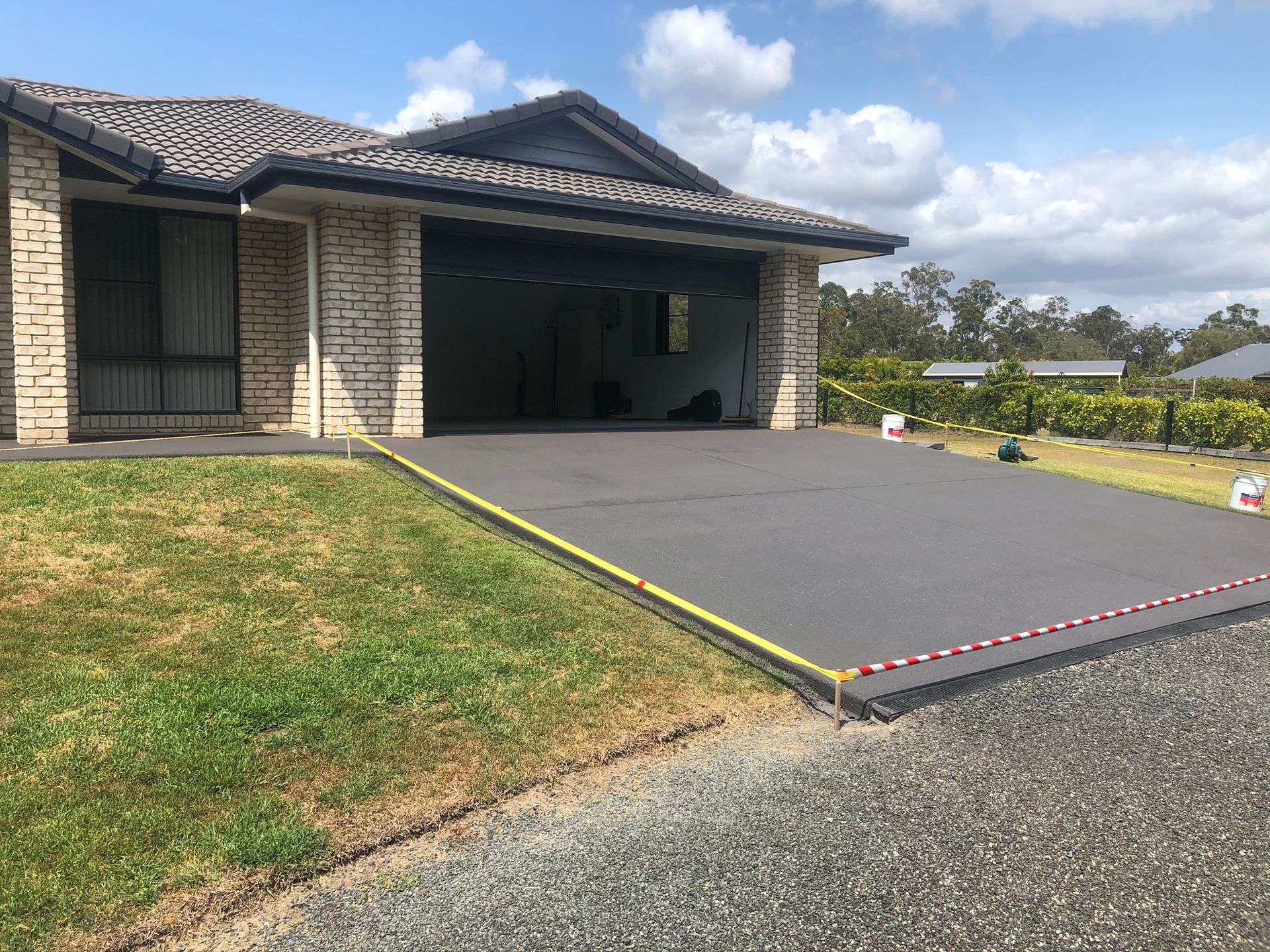 A House With a Concrete Driveway in Front of It — Grafton Concreting & Bobcat Services In South Grafton, NSW