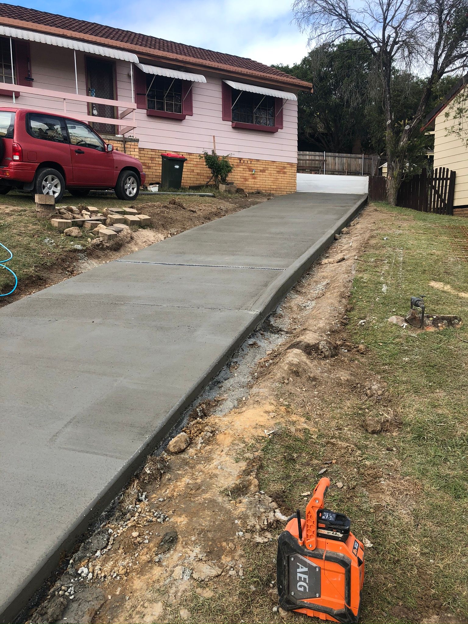A Concrete Driveway is Being Built in Front of a House — Grafton Concreting & Bobcat Services In South Grafton, NSW