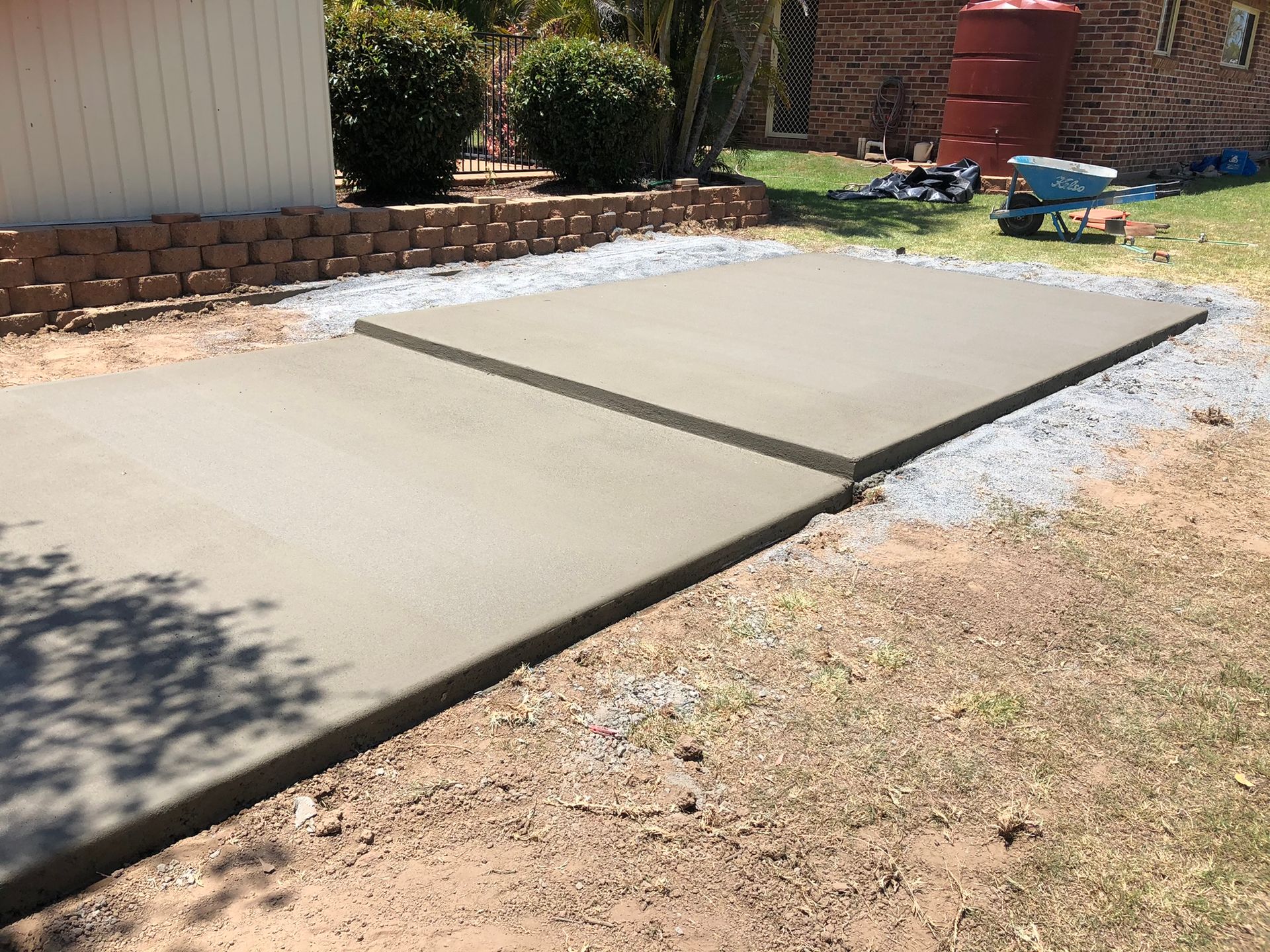 A Concrete Walkway is Being Built in the Backyard of a House — Grafton Concreting & Bobcat Services In South Grafton, NSW