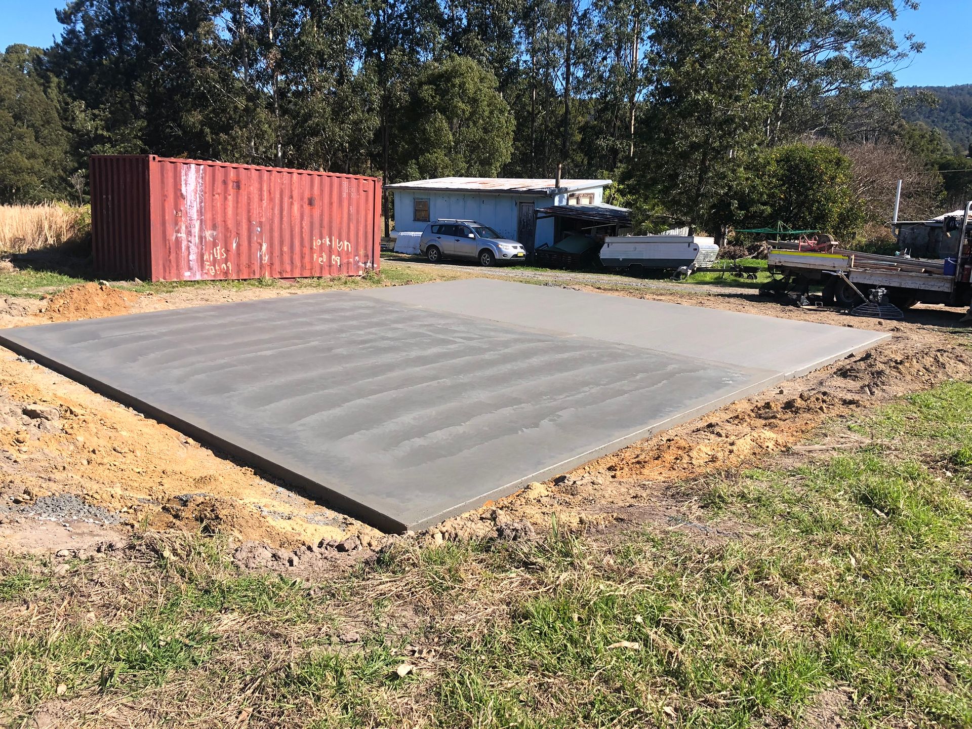 A Large Concrete Slab is Sitting in the Middle of a Grassy Field — Grafton Concreting & Bobcat Services In South Grafton, NSW