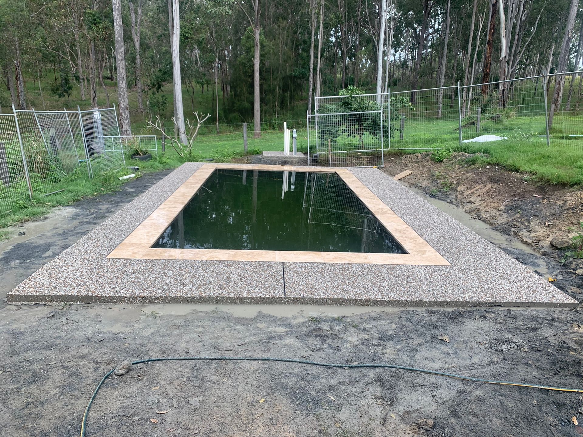 A Swimming Pool is Being Built in the Middle of a Dirt Field — Grafton Concreting & Bobcat Services In South Grafton, NSW