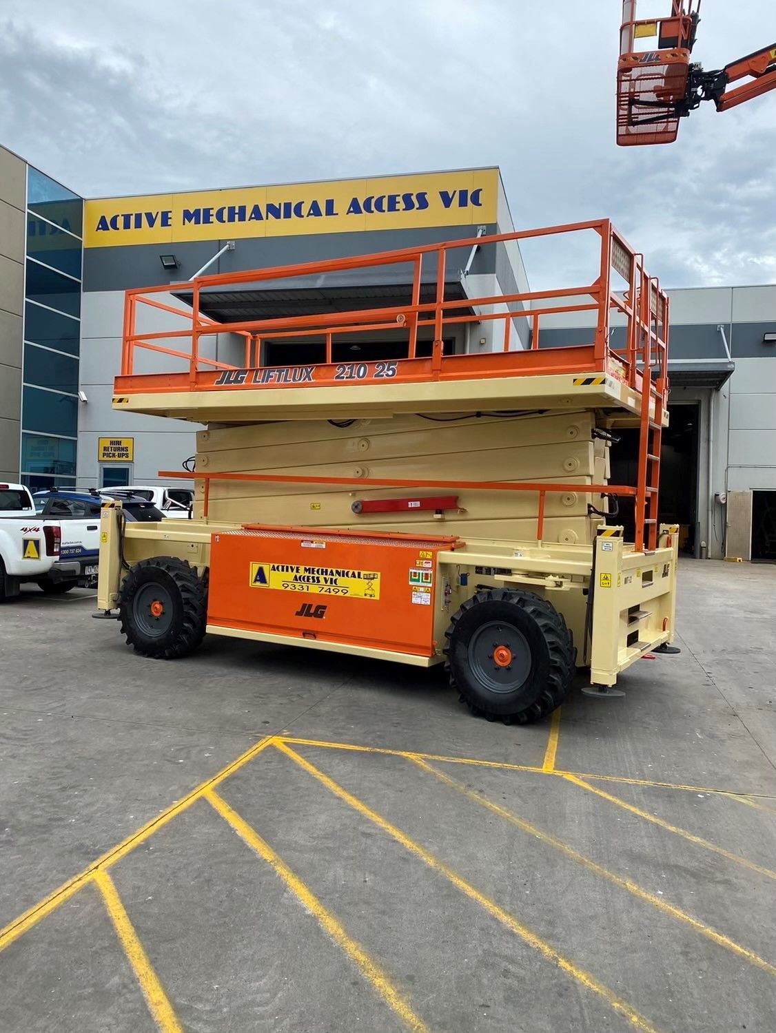 A crane is sitting in front of a brick building.