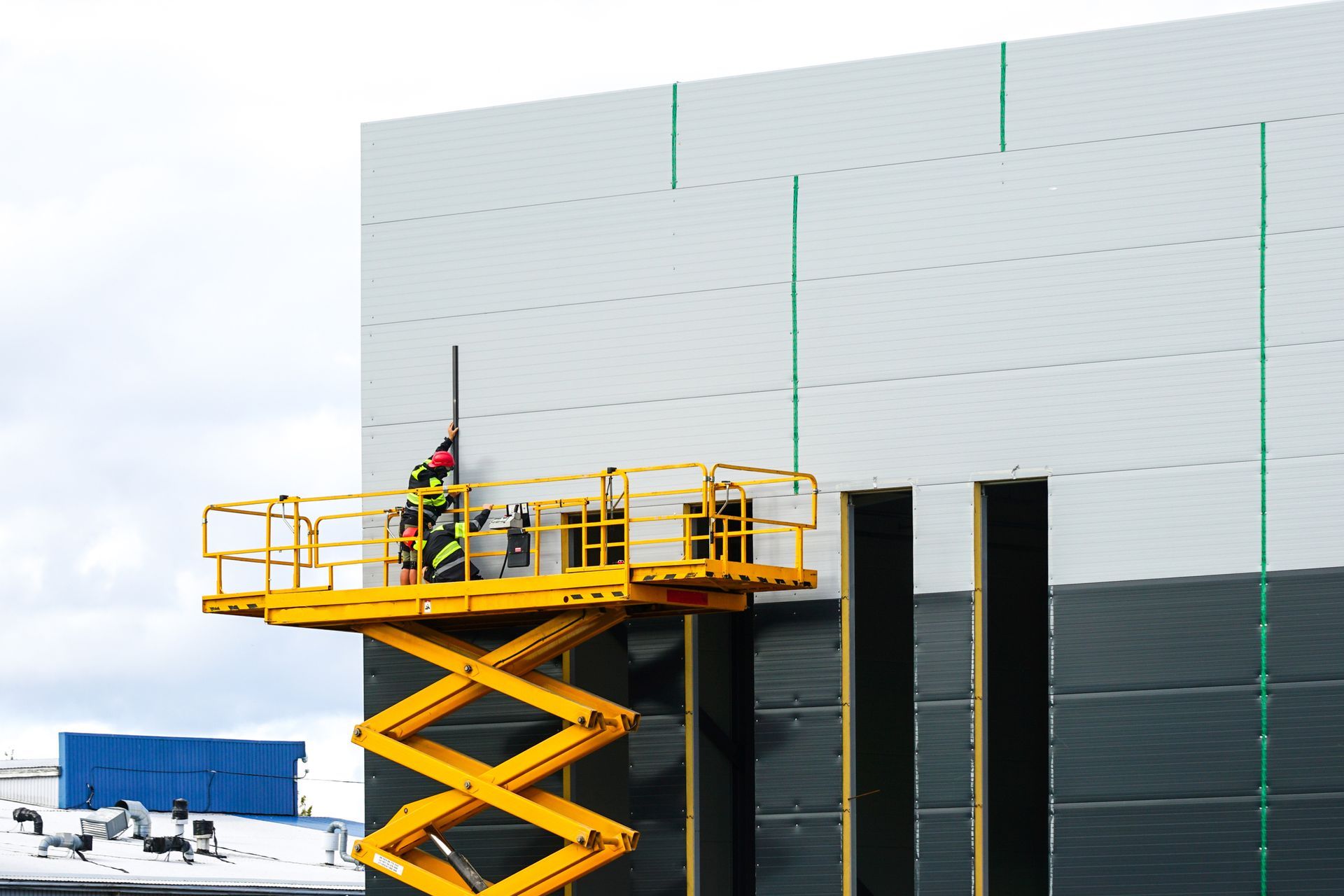 Orange telescopic boom lift with extended arm on white background – industrial boom lifts equipment.