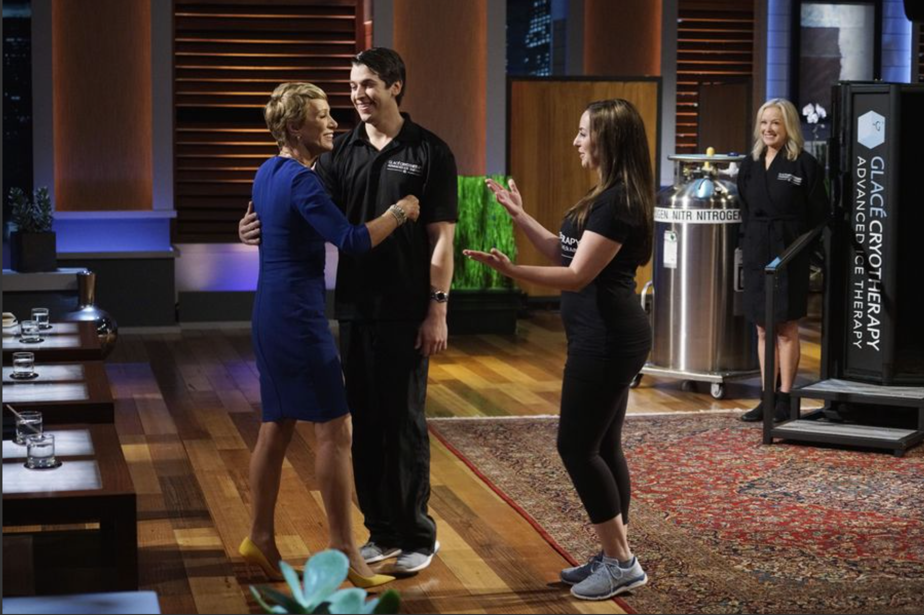 a man and a woman are hugging each other on a stage called Shark Tank after showing off whole body cryotherapy