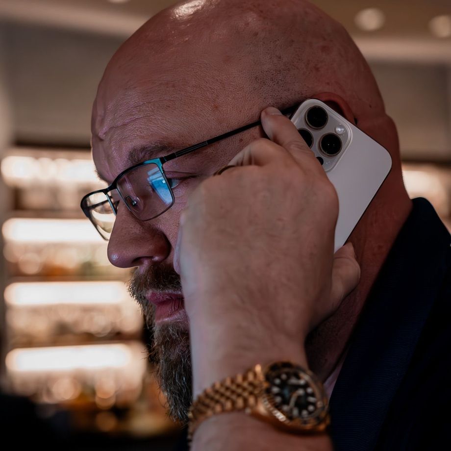 A man wearing glasses is talking on a cell phone