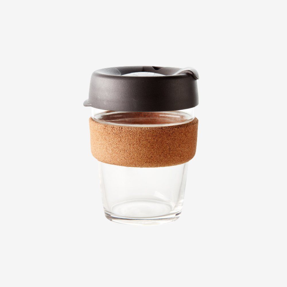 A clear glass coffee cup with a cork handle and lid.