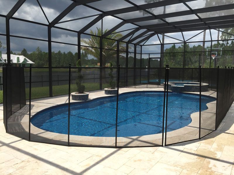 A screened in swimming pool with a black fence around it