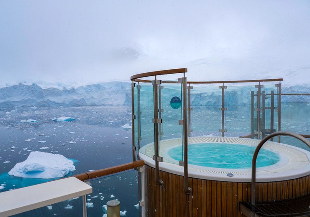 There is a hot tub on the deck of a boat in the middle of the ocean.