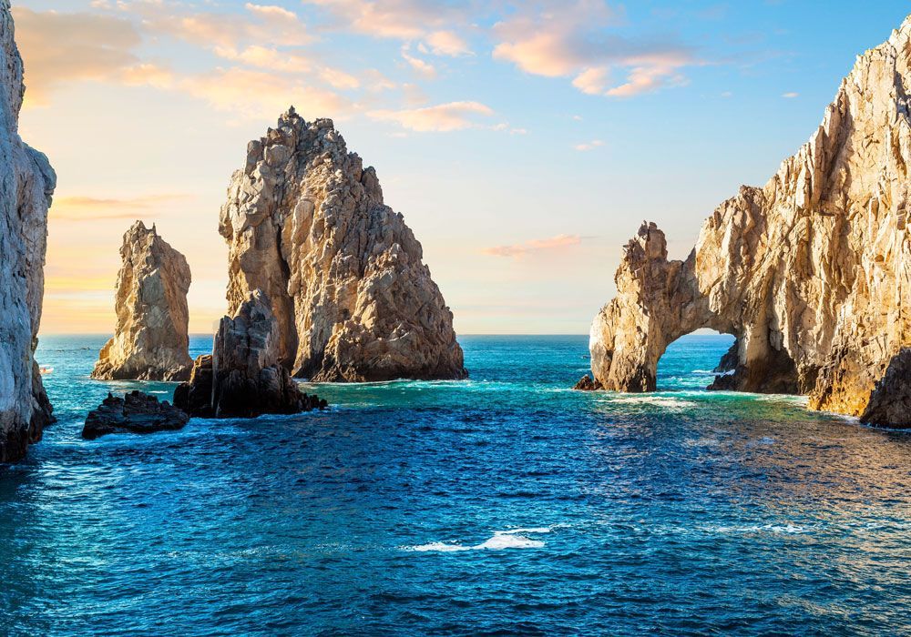 A large rock formation in the middle of the ocean.