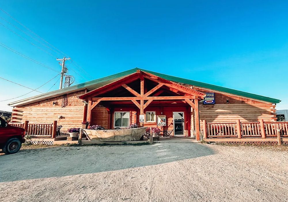 Wooden building with red accents, under a clear blue sky.