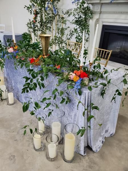 Decorated altar with white cloth, candles, flowers, and greenery in a church sanctuary