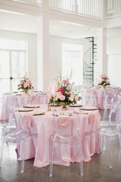 Pink floral wedding reception tables in a bright white room