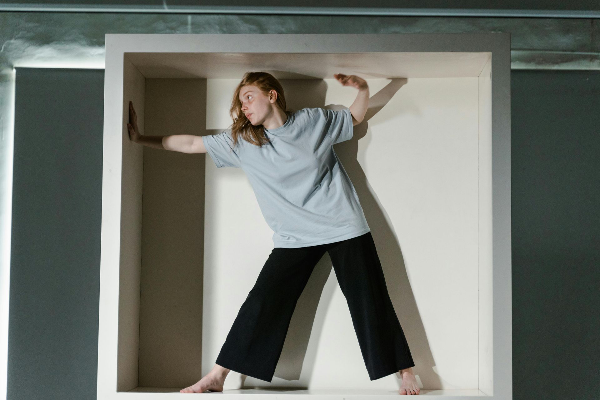 A woman is standing in a white box.