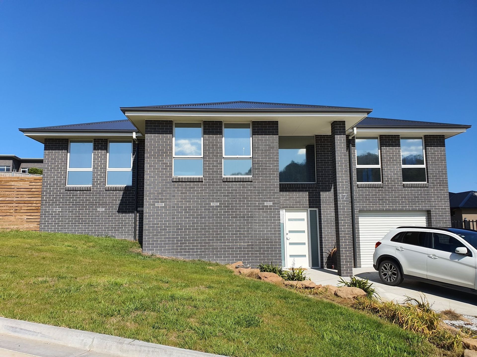 A Modern, Single-story Gray Brick House With a White Garage Door — Shmick Tinting & Vinyl in North Hobart, TAS