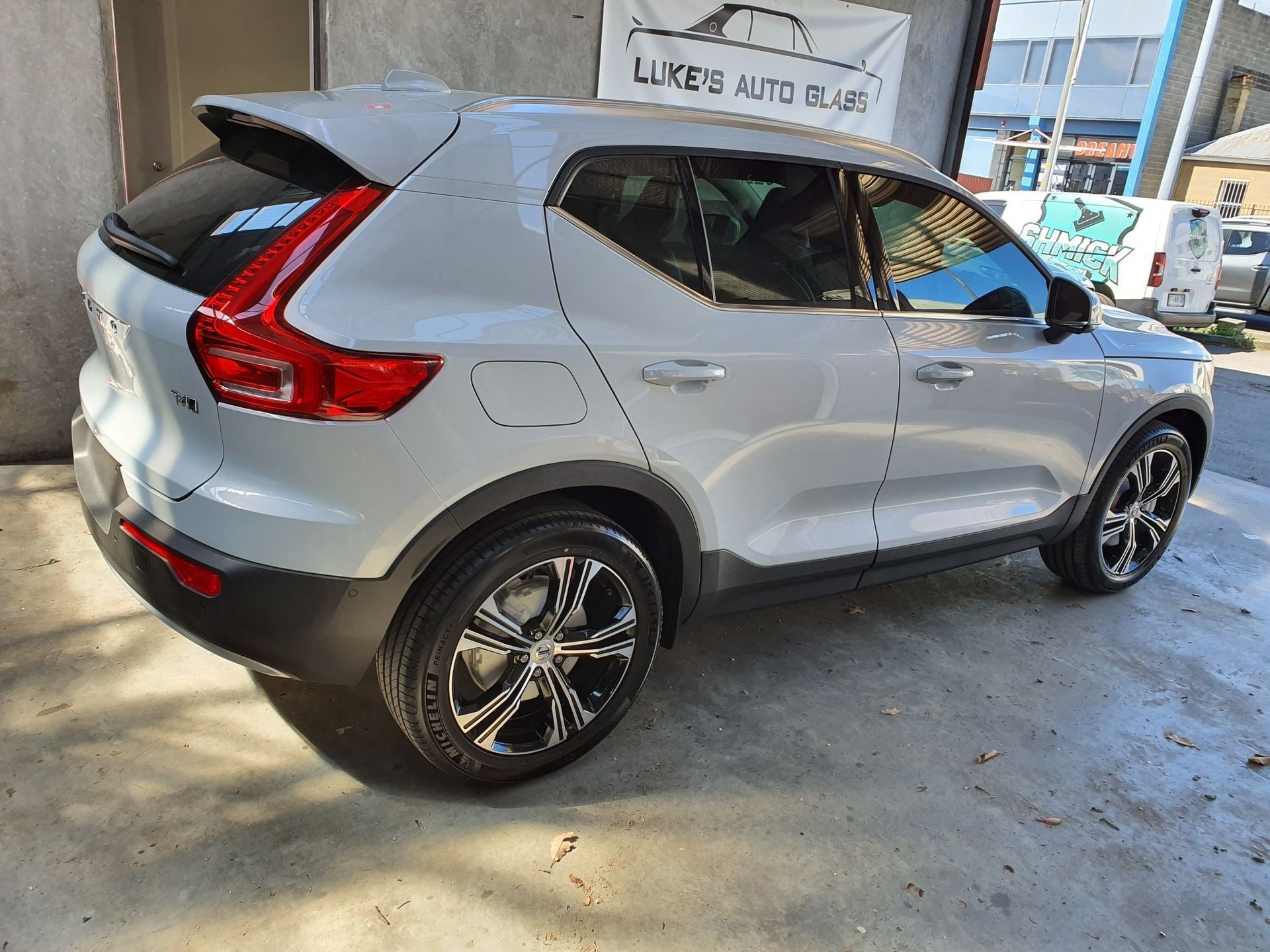 Silver Volvo SUV parked in a garage, rear three-quarter view
