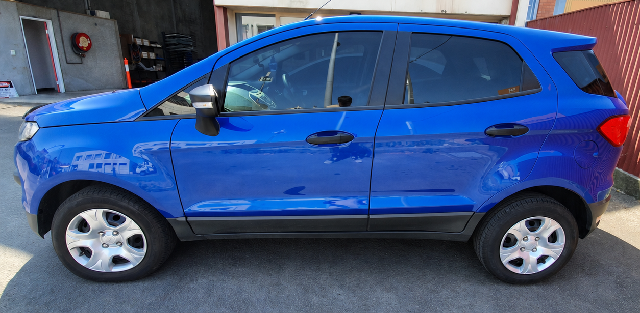 Blue compact SUV parked on a street, side view, with a dented front-left fender.