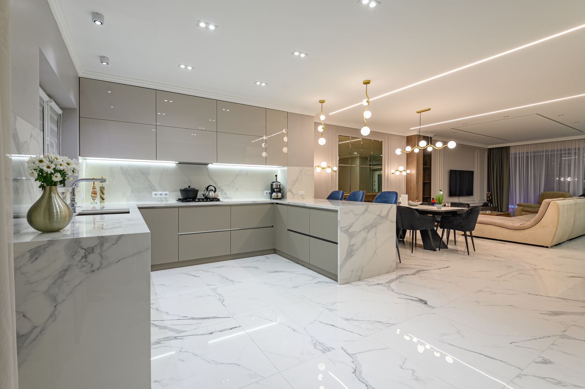 A kitchen and dining room in a modern house with marble floors.