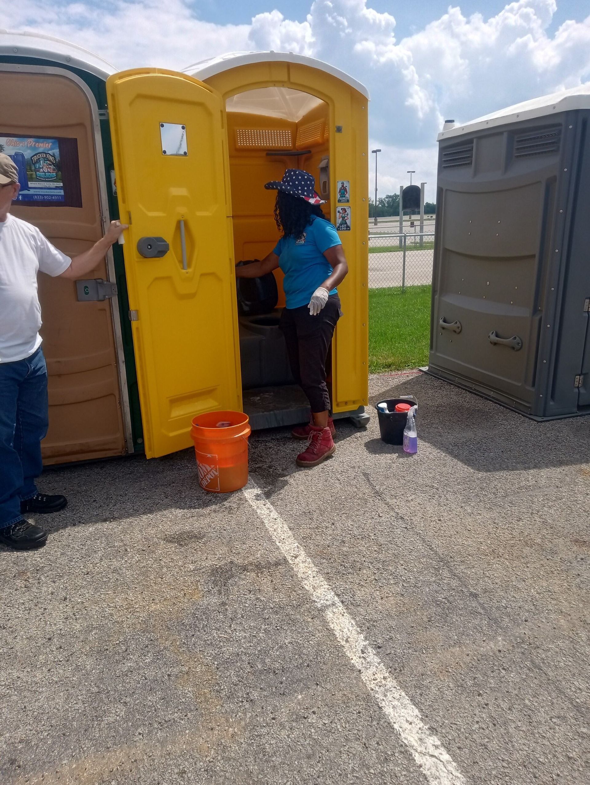 Portable restroom service worker cleaning a portable toilet before an event