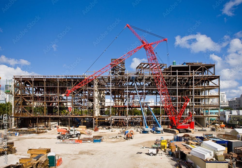 A large building is being built with a lot of cranes.