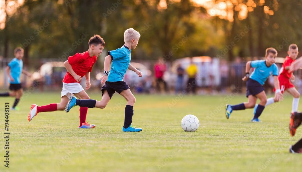 A group of young boys are playing soccer on a field.