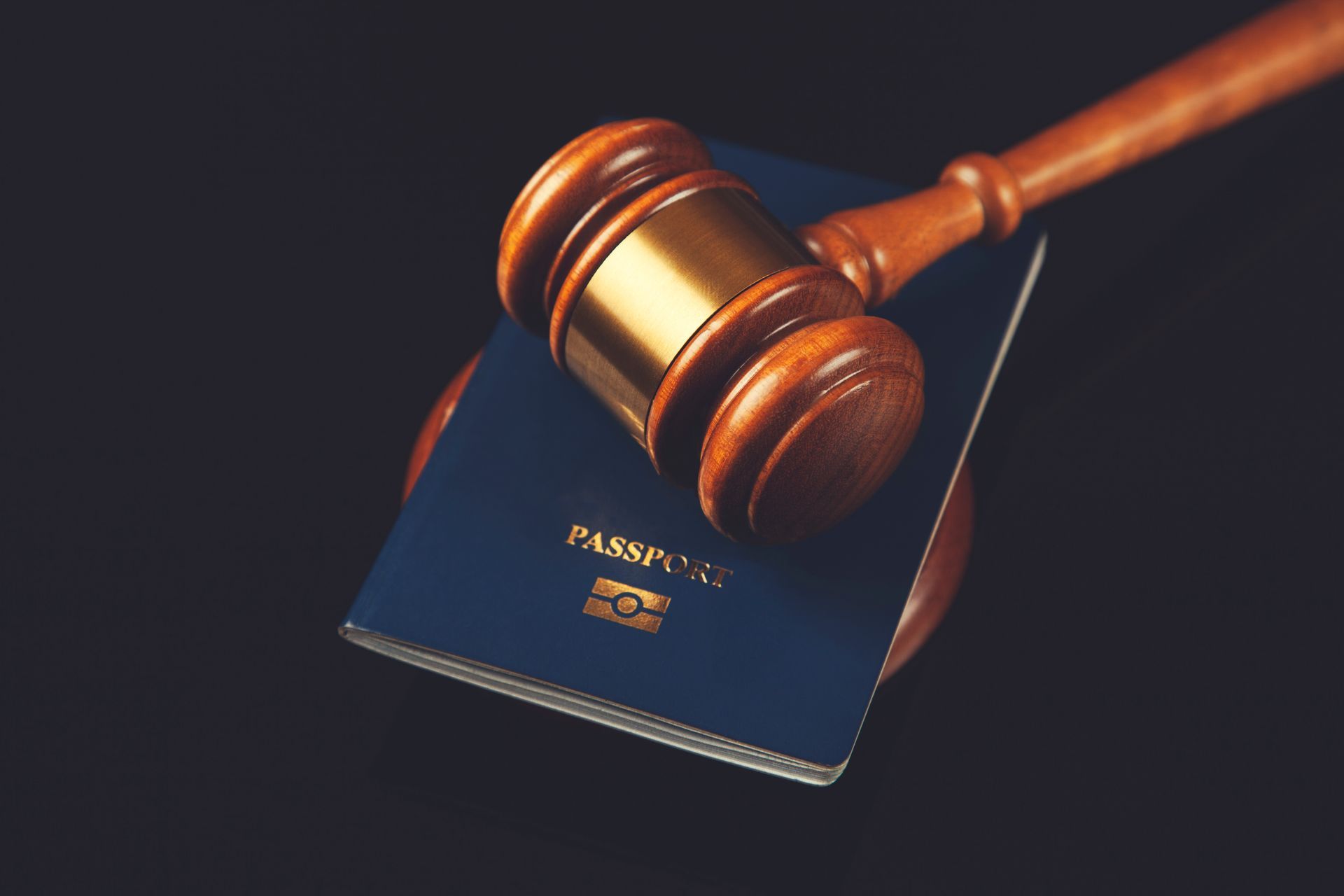 Judge’s gavel resting on a passport against a dark background, symbolizing legal immigration matters.