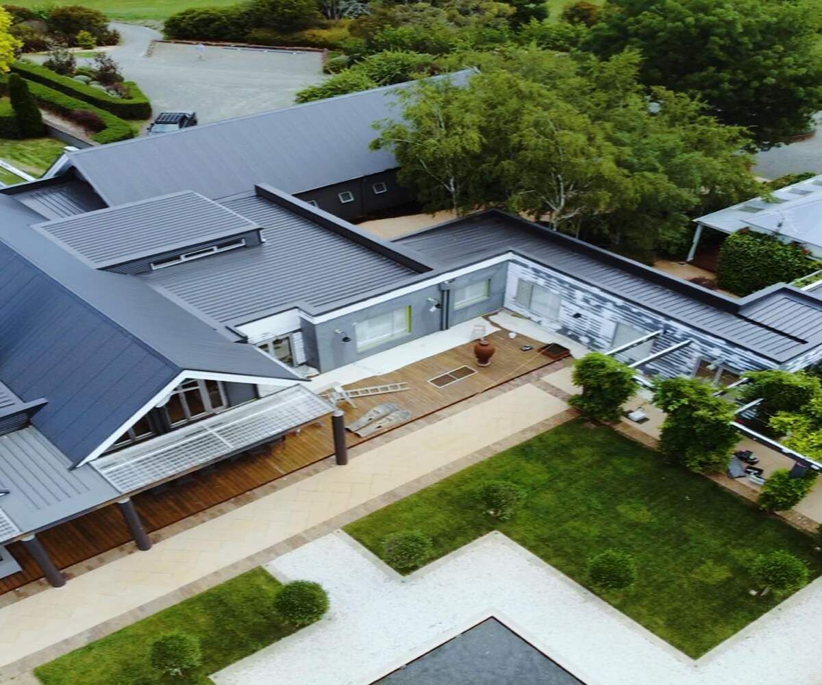 An Aerial View Of A Large House Surrounded By Trees And Grass — Elevated Roofing Systems Pty Ltd In Barrack Heights, NSW
