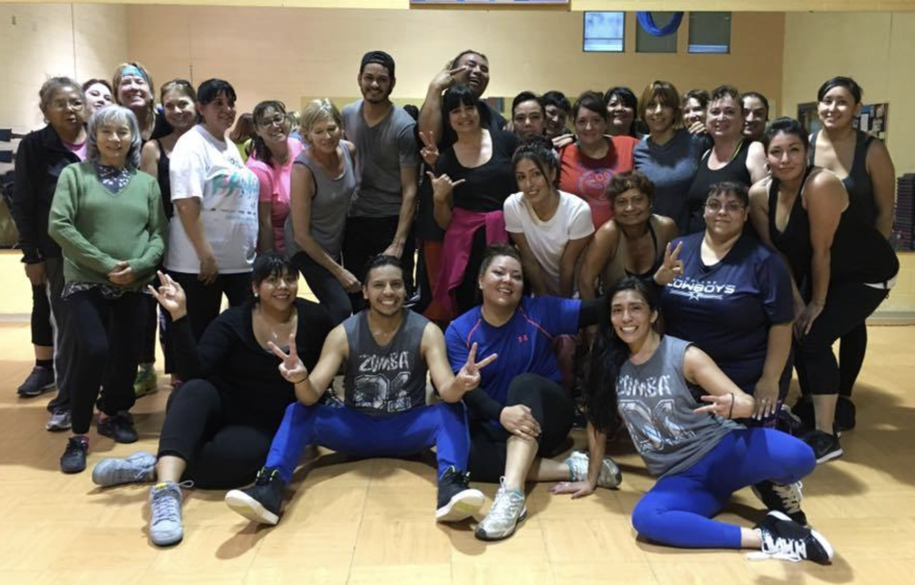 A group of people are posing for a picture in a gym.