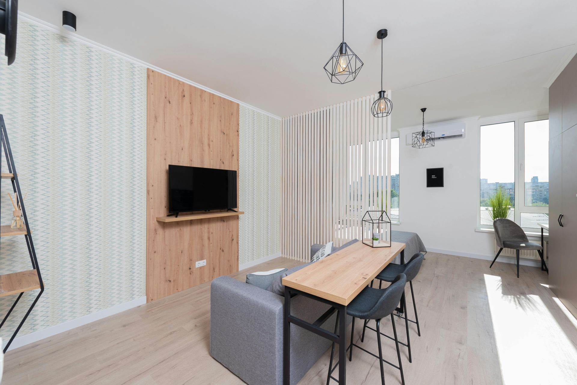 Modern studio apartment with wooden accents, TV, and dining table.