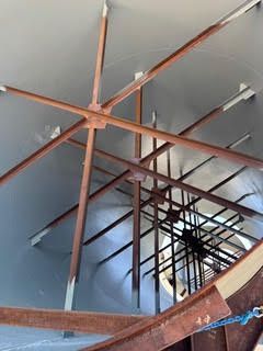 Spiral staircase interior with metal railings and large wooden star-shaped ceiling fixture