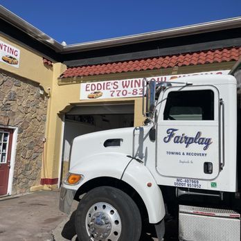 White Fairplay towing truck parked outside Eddie’s Window Tinting shop.