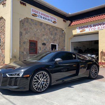 Black sports coupe parked outside Eddie’s Window Tinting shop on a sunny day